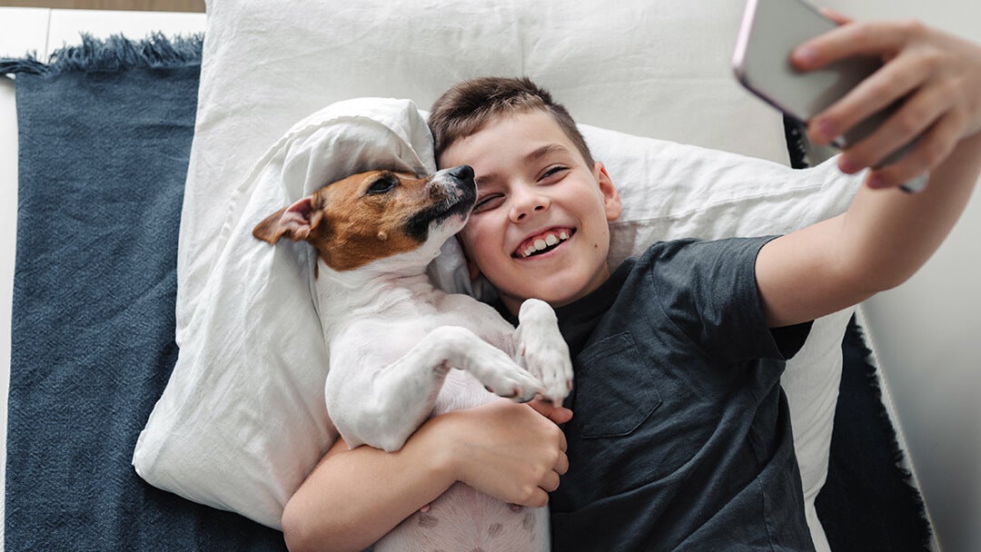 boy taking a selfie with his dog