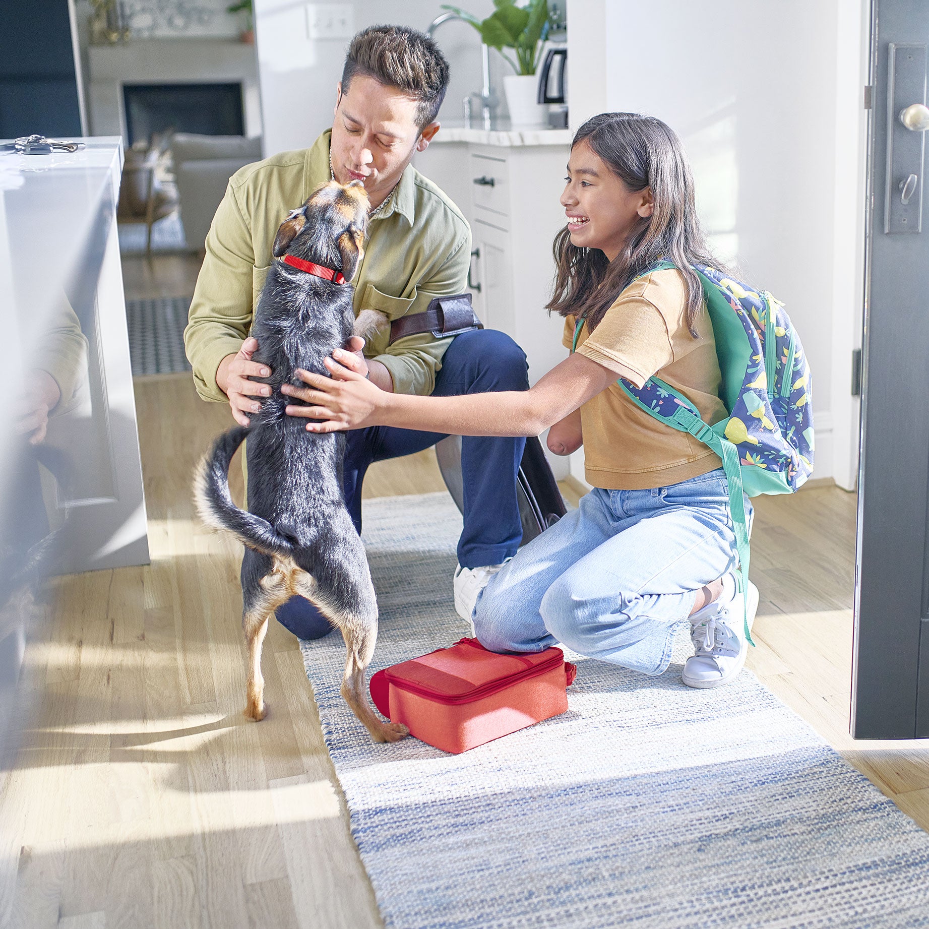 Dad and daughter are playing with a dog